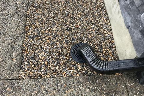 Downspout extension and yard drainage carrying roof water away from a foundation